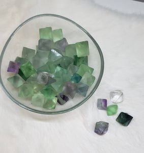 Various sizes of Fluorite crystals in their natural diamond shape in various colours ranging from green, light green, purple, and clear.